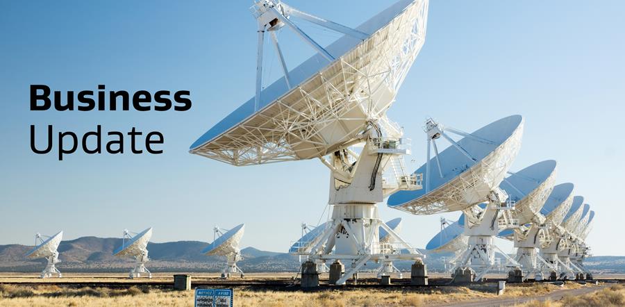 Text: Business Update. Background is an image of ground stations in the desert. 